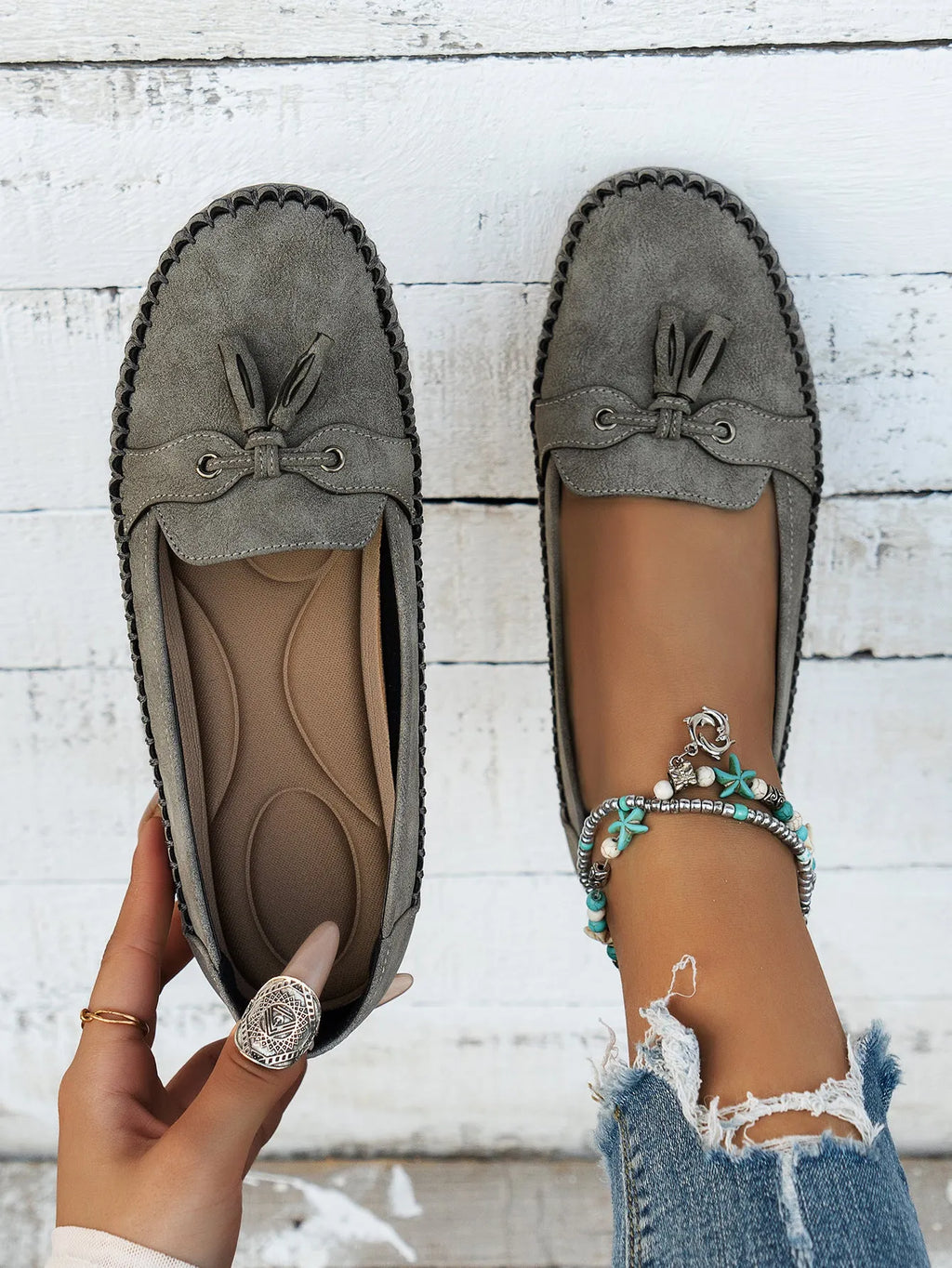Women's suede casual flat shoes with a bow detail in pink, shown from the side.