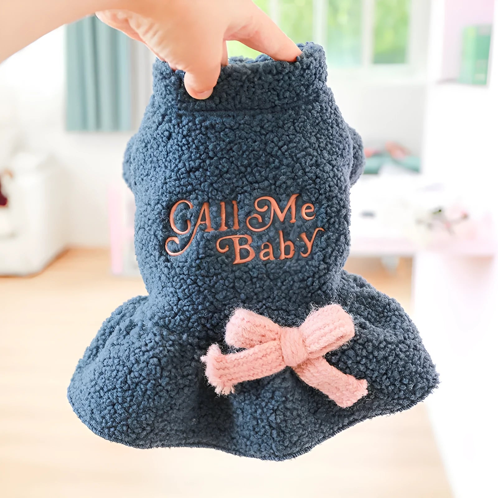 Pet dog wearing a pink baby letter patterned fleece skirt, showing the casual fit and soft polyester material.