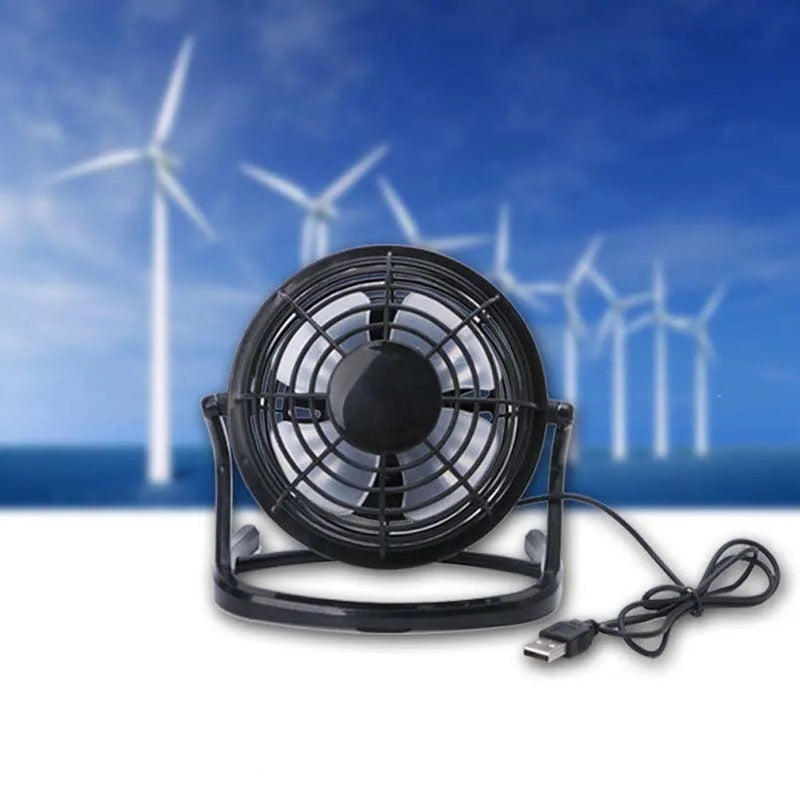Mini USB desk fan with adjustable angle in black colour beside laptop
