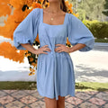 Orange red children's backless dress with square collar and puff sleeves on a mannequin.