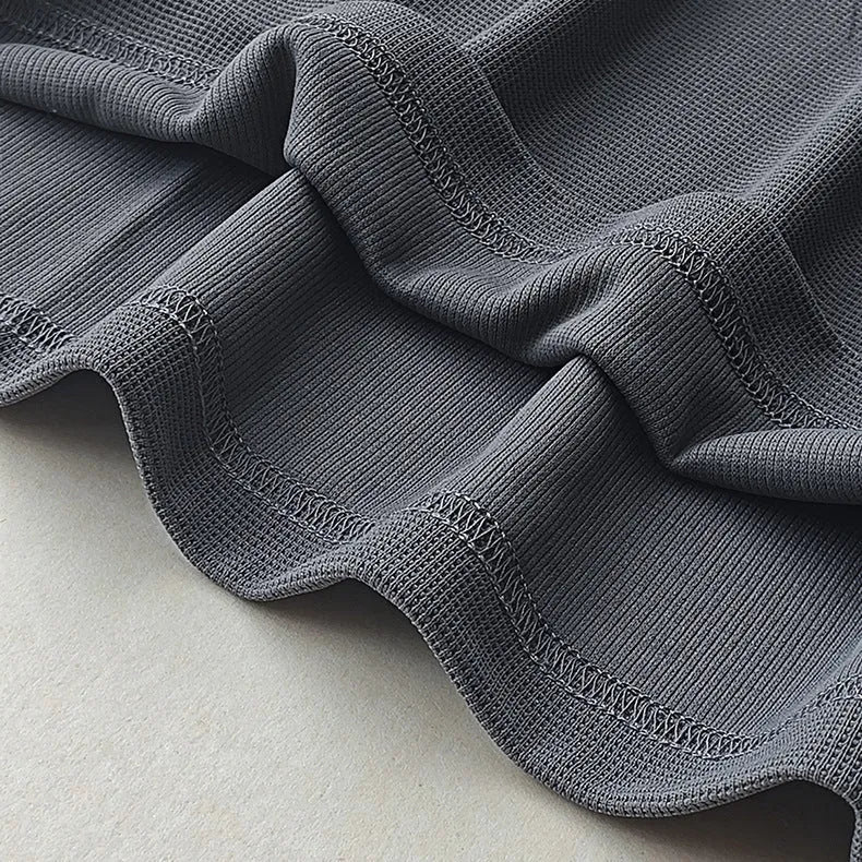Men's dark grey waffle-knit short sleeve T-shirt showing textured fabric detail.