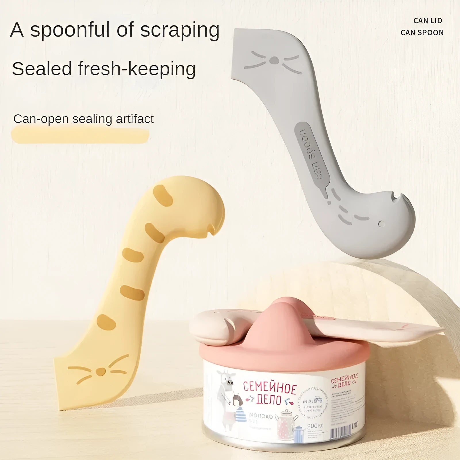 Grey silicone pet food can sealing lid and mixing spoon with integrated can opener on a white background.