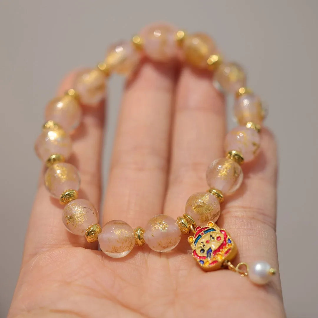 Close-up of a manually crafted gold foil coloured glaze ethnic bracelet for women, showing geometric design.