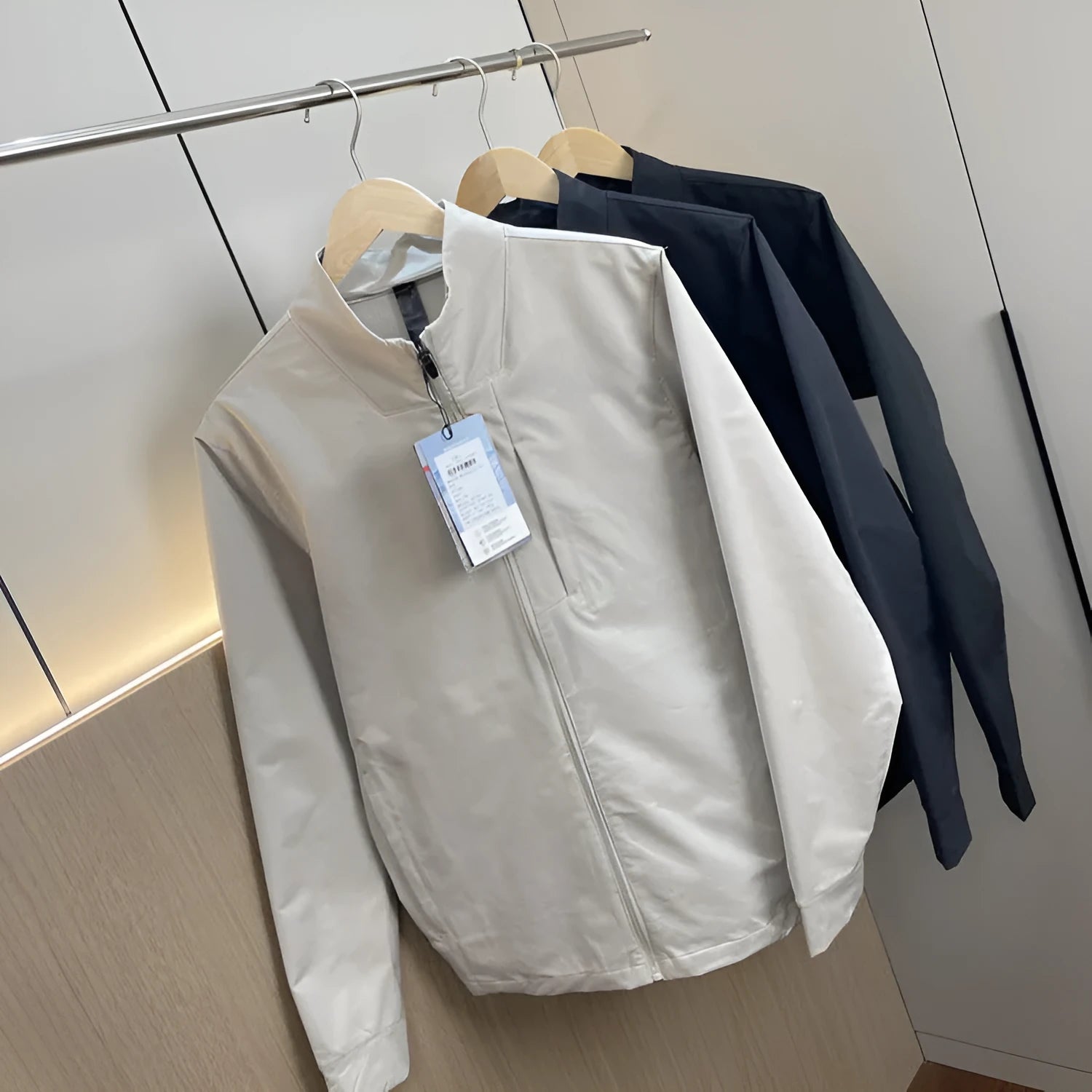 Men's beige stand collar polyester casual jacket with long sleeves and straight hem.