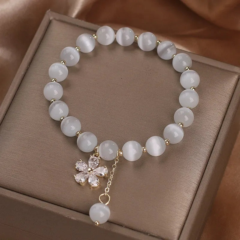 White cat's eye stone bracelet with flower tassel detail and morganite safety buckle pendant