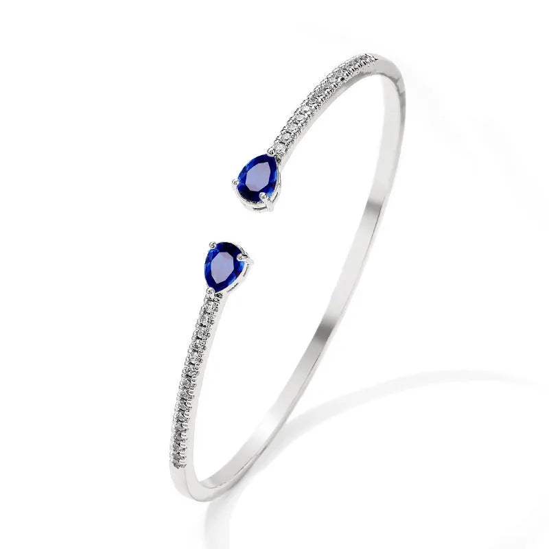 Multi-zircon copper bracelet with zircon inlaid detailing available in white or blue colour
