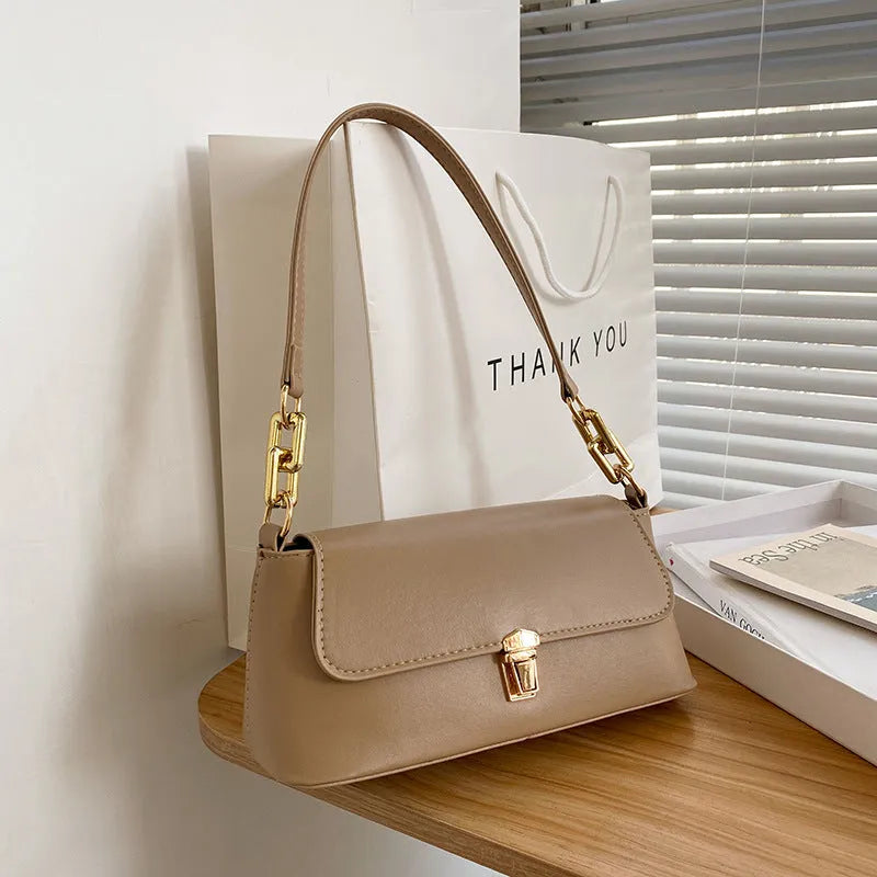 Brown French style casual underarm bag with a single shoulder chain, showing sandwich pocket and sewing thread detail.