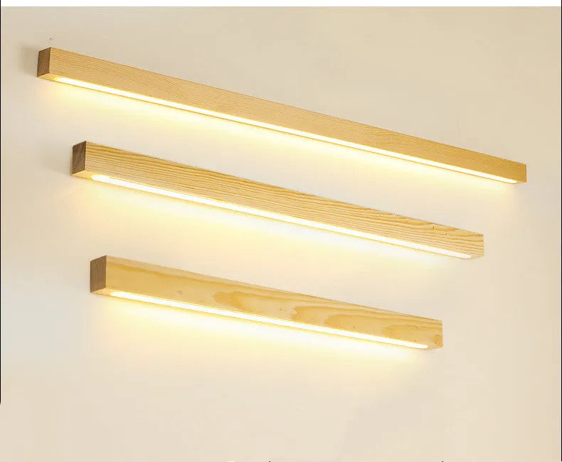 Slim walnut-coloured wood and acrylic LED strip wall lamp mounted on a wall in a modern room.