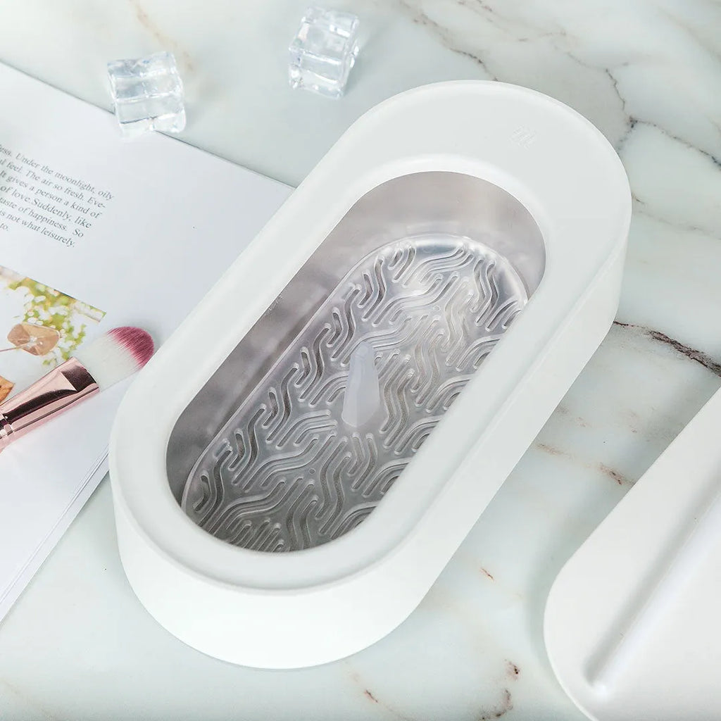 White portable ultrasonic cleaner with stainless steel tank and touch button.