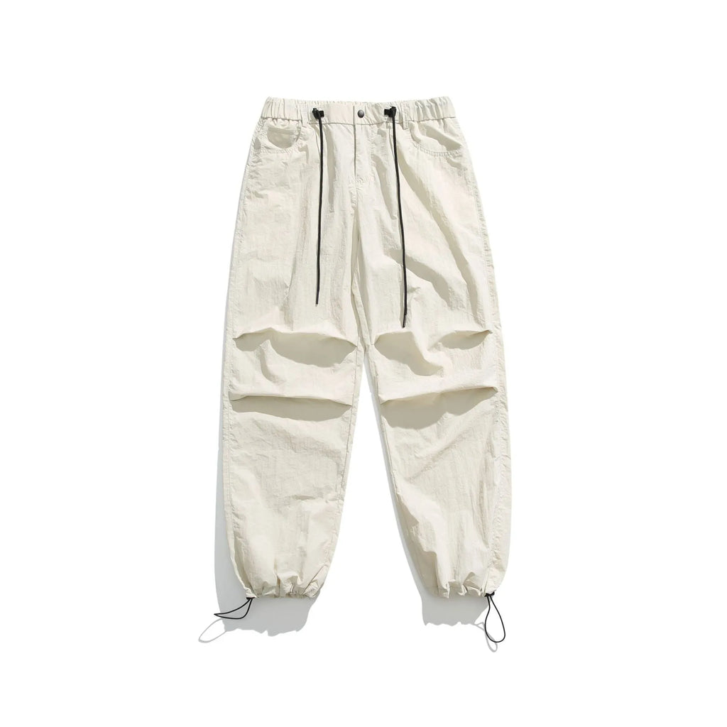 Man wearing thin ice silk loose straight leg casual trousers in a neutral colour with an elasticated waistband.
