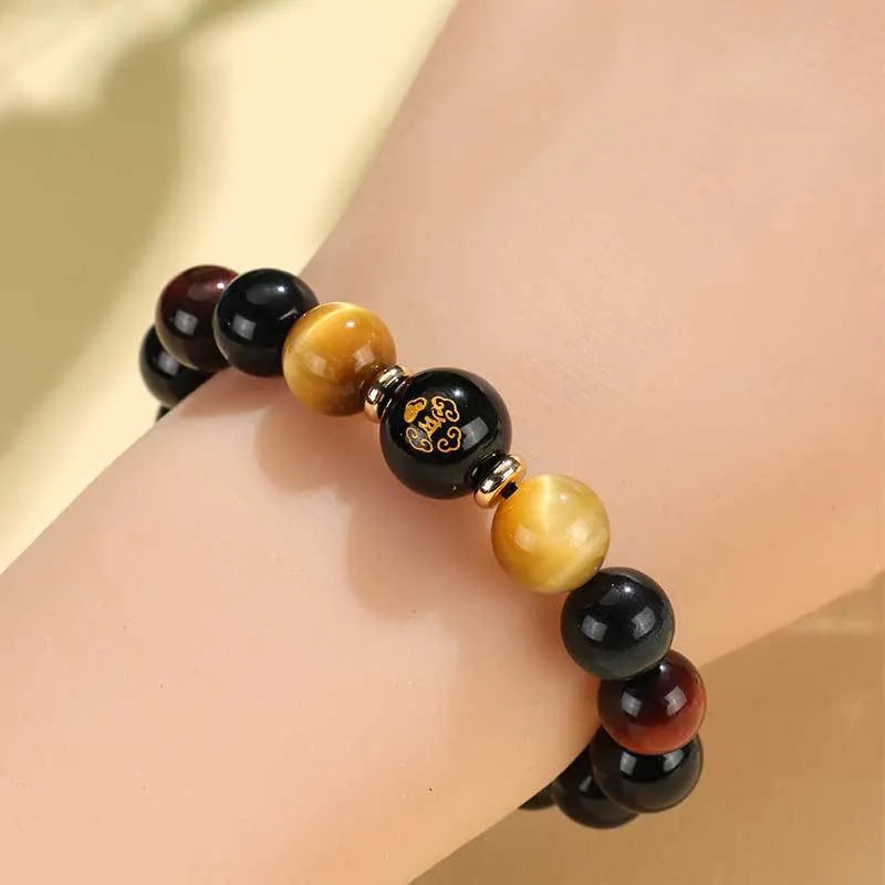 Black agate beaded bracelet with carved Buddhist charm and tiger eye stones