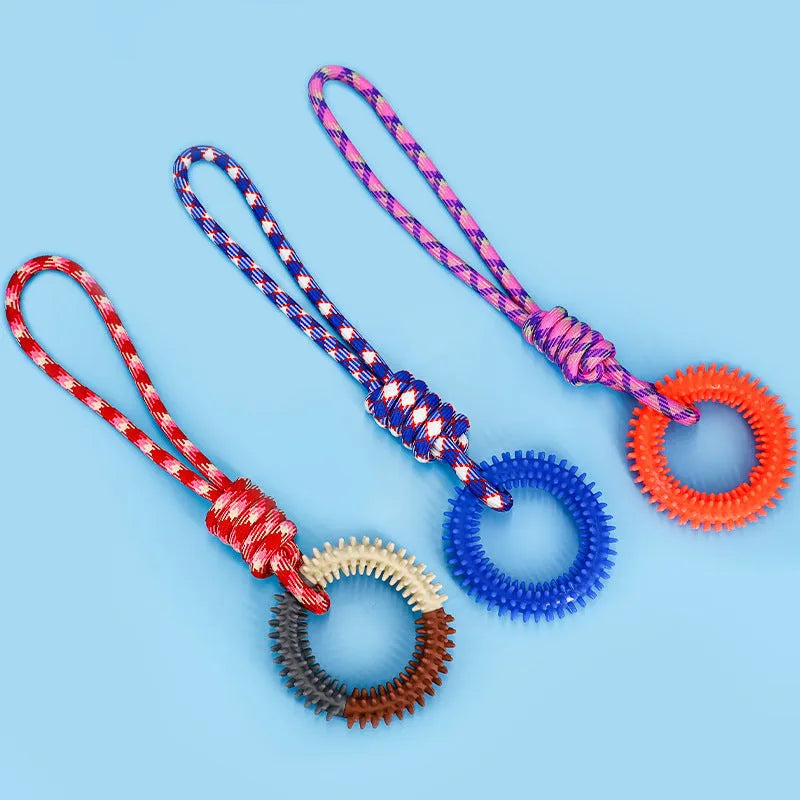 Blue braided rope dog chew toy with a large central knot on a wooden floor