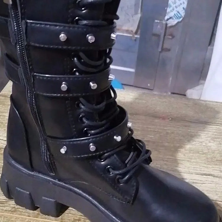 A pair of women's black mid-calf knight boots with a side zip and a large metal buckle strap.