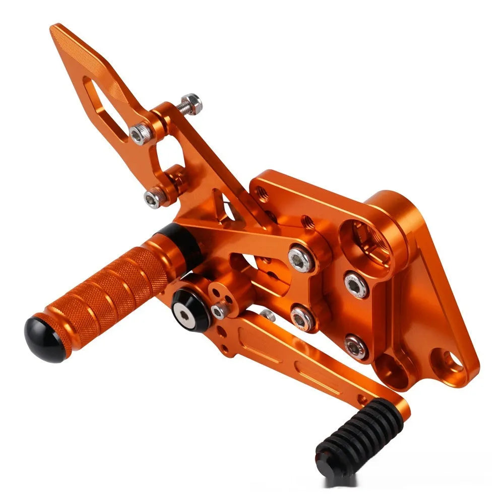 Black and orange KTM Duke motorcycle pedal support bracket assembly