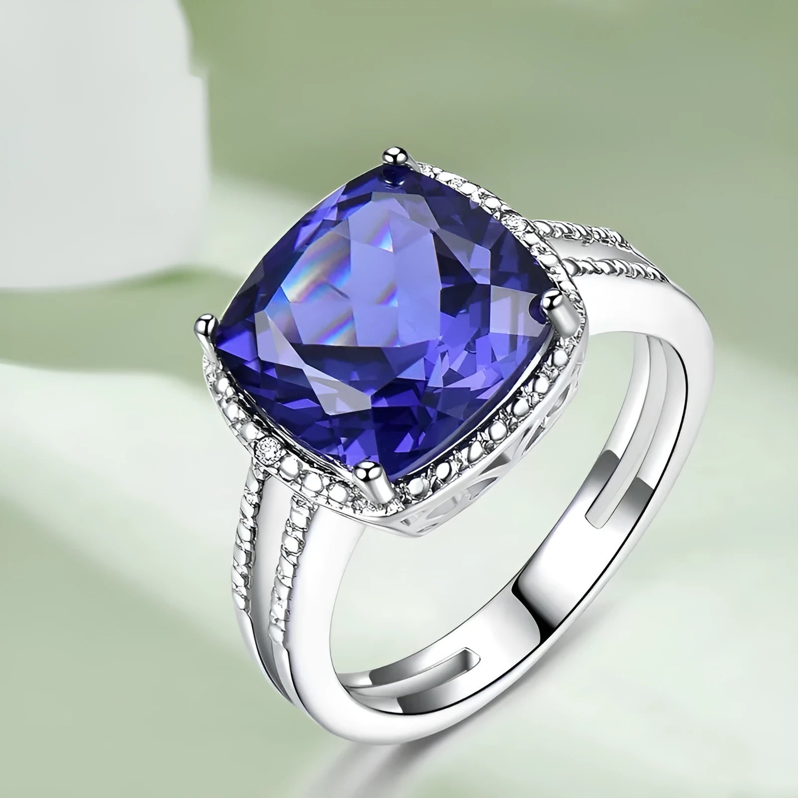 Blue tanzanite stone set in a sterling silver women's ring on a white background.