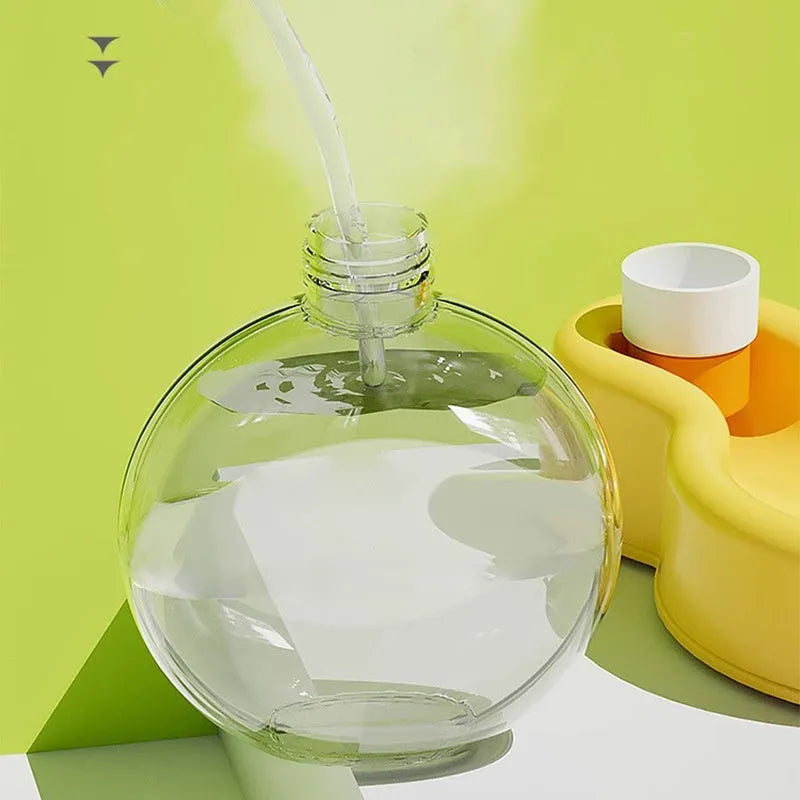 Green portable dog water bottle with pull-out drinking bowl on grass, showing travel cup design.