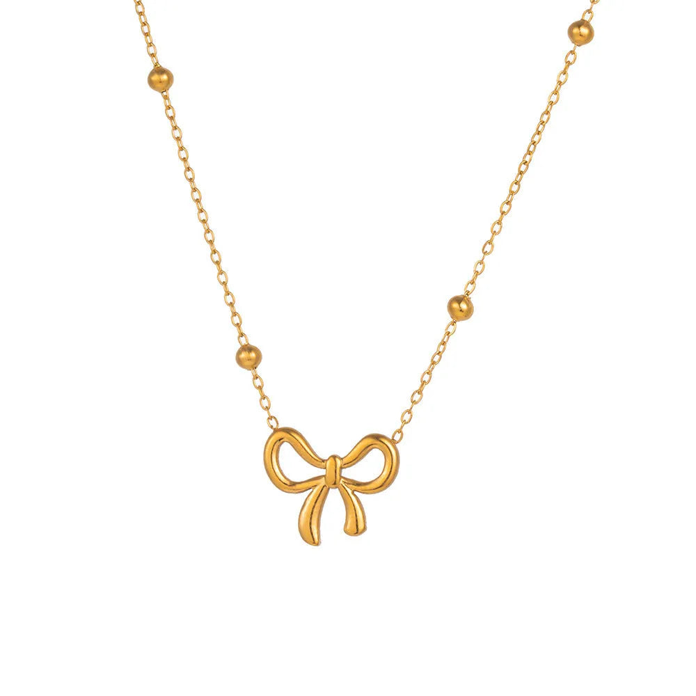 Gold coloured bow pendant necklace on a cross chain, showing adjustable length.
