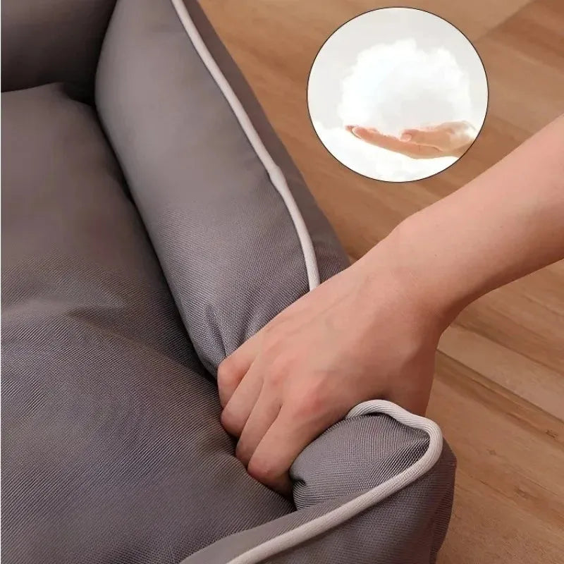 Grey waterproof dog sofa bed with raised edges, shown in a living room setting.
