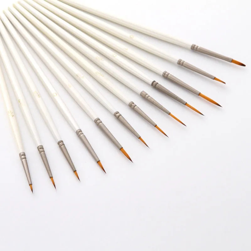 Set of 12 pearl white artist painting brushes with wooden handles and nylon wool fibres.