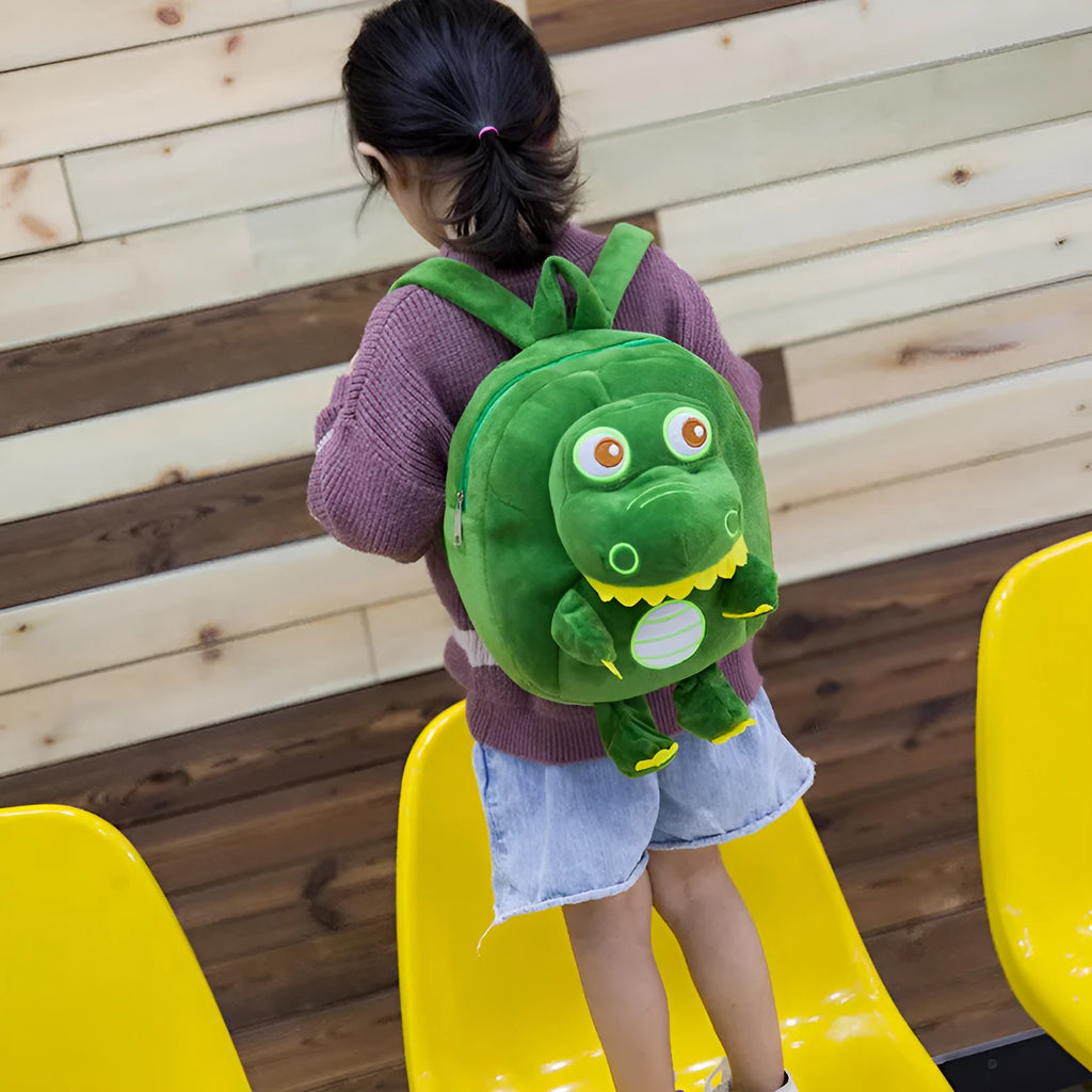 Blue soft plush dinosaur character backpack with embroidery, shown with a soft handle and backpack straps.