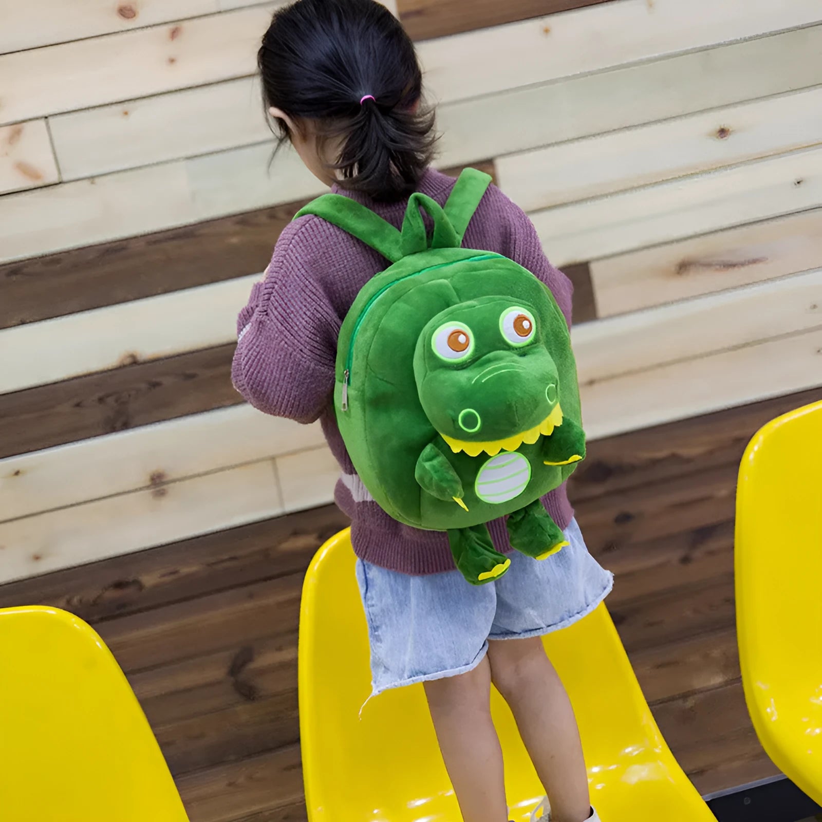 Blue soft plush dinosaur character backpack with embroidery, shown with a soft handle and backpack straps.