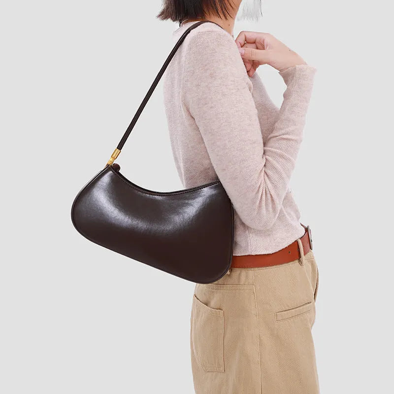 Oval-shaped brown PU leather women's underarm handbag with a single shoulder strap and visible stitching.