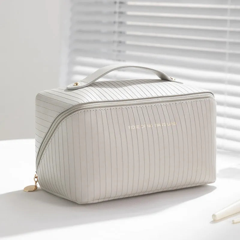 Vertical pattern cubic PU leather makeup bag in beige, shown open to display large capacity interior.