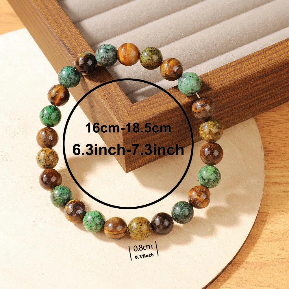 Handmade tigereye stone bracelet with 18mm flower bead in antique style on wrist.