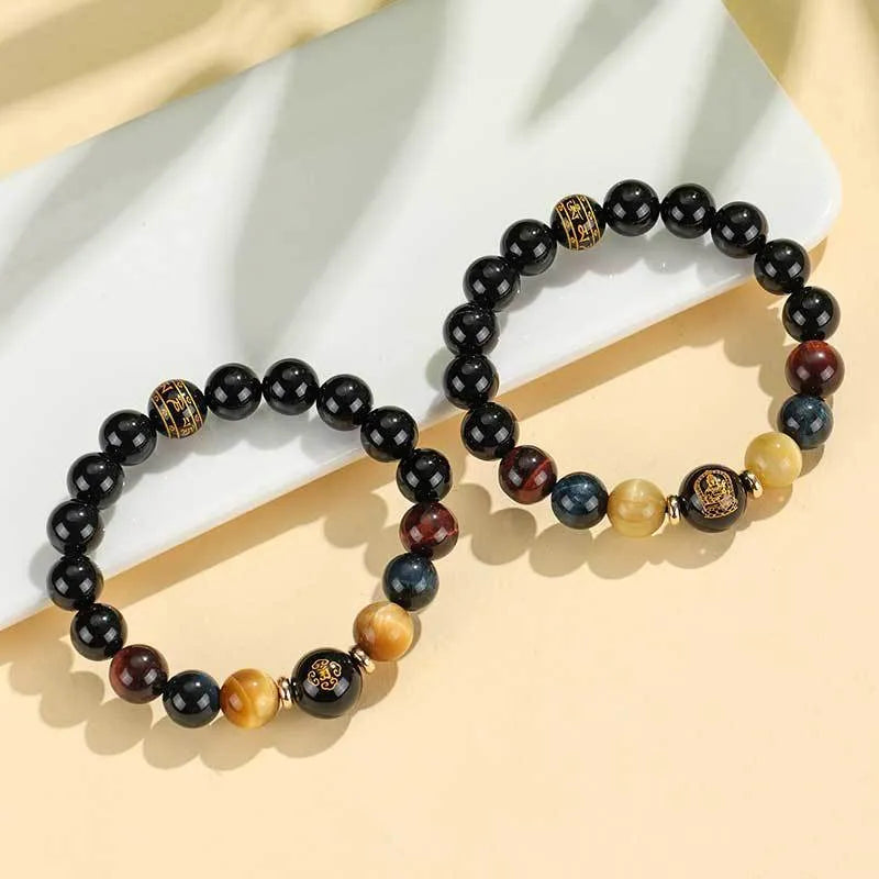 Black agate beaded bracelet with carved Buddhist charm and tiger eye stones