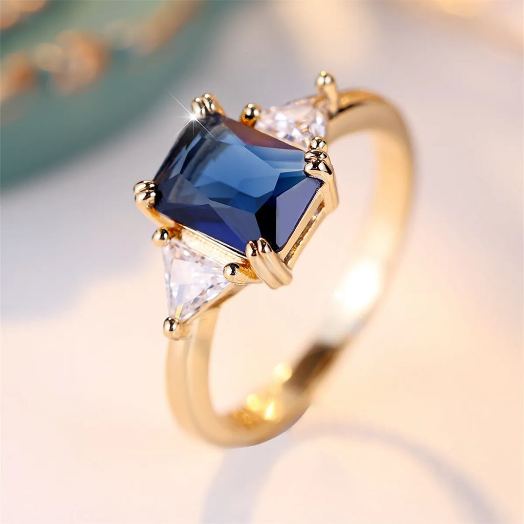 A rectangular copper fashion ring for women with a gold sapphire blue finish.