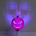 Plastic pumpkin-shaped decorative lamp with USB charging cable, showing purple or yellow light option.