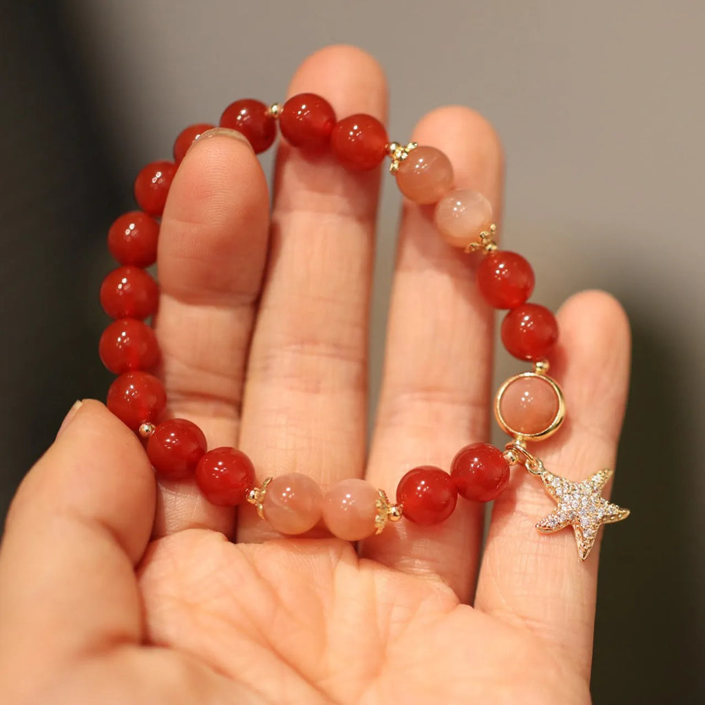 Handmade ethnic-style bracelet with sand orange Sunstone and 8mm red agate beads in a star pattern.