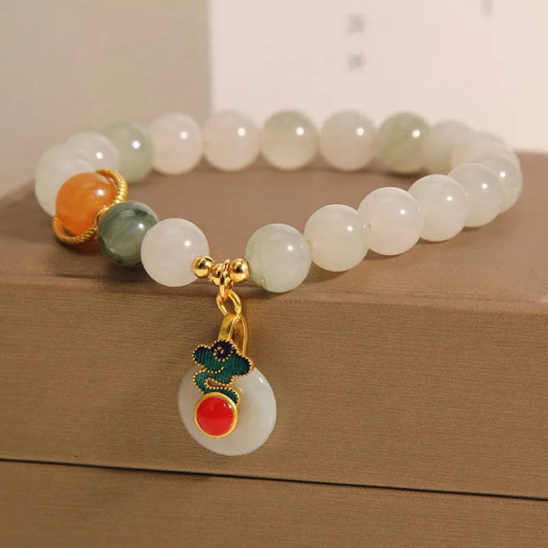 Close-up of a women's ice jade bracelet with a xiangyun peace buckle and pearl detail.