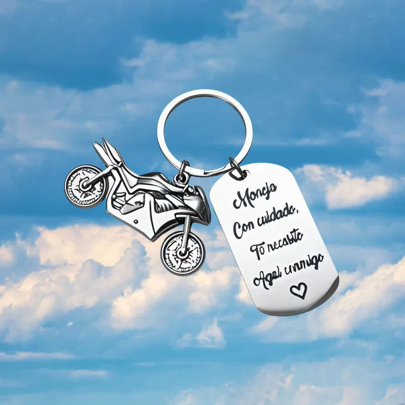 Stainless steel motorcycle keychain with inspirational design, shown with its included flannel storage bag.