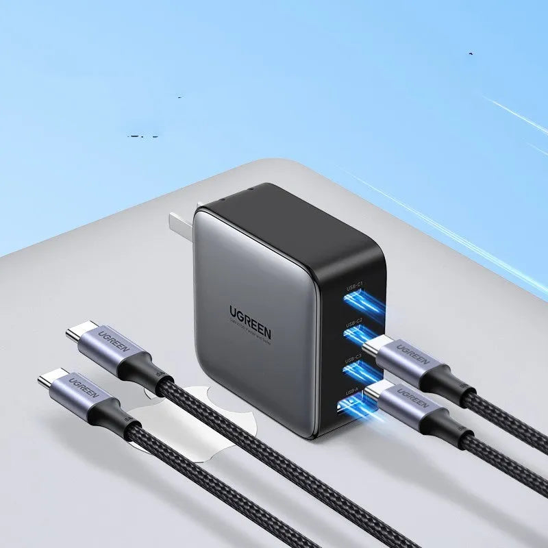 100W Gallium Nitride fast wall charger with USB-C port on a desk next to a laptop.