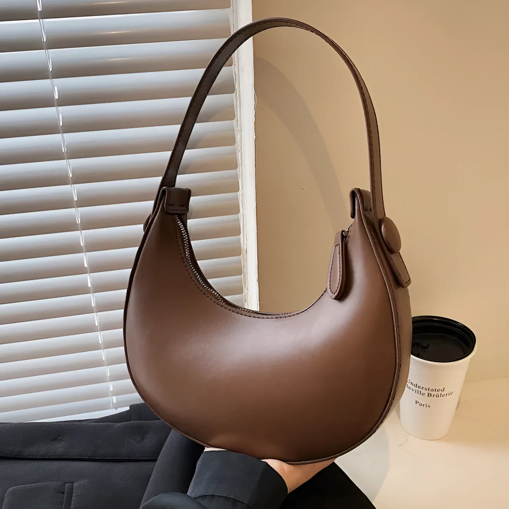 Retro dumpling-shaped black PU leather women's shoulder bag with a front sandwich pocket.