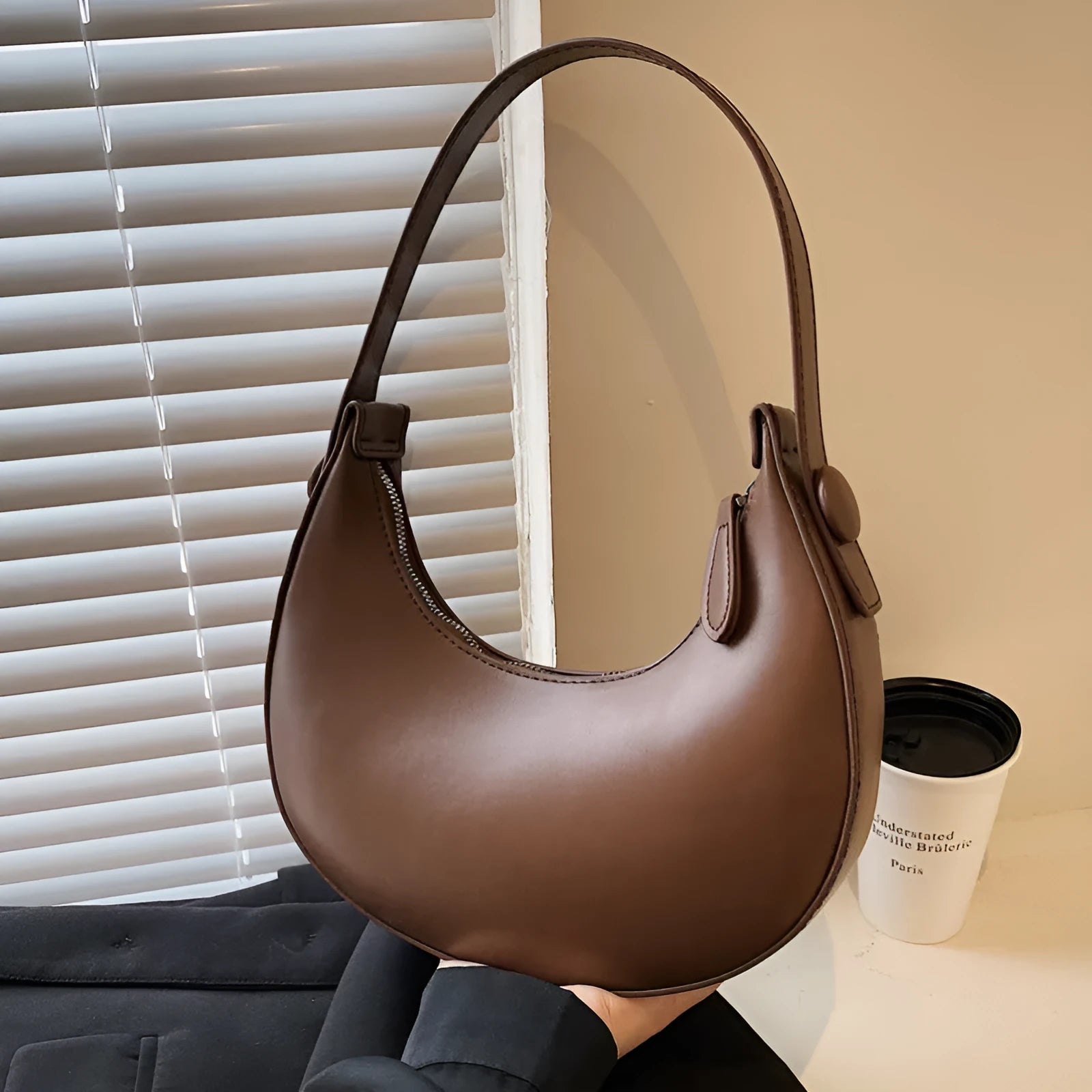 Retro dumpling-shaped black PU leather women's shoulder bag with a front sandwich pocket.