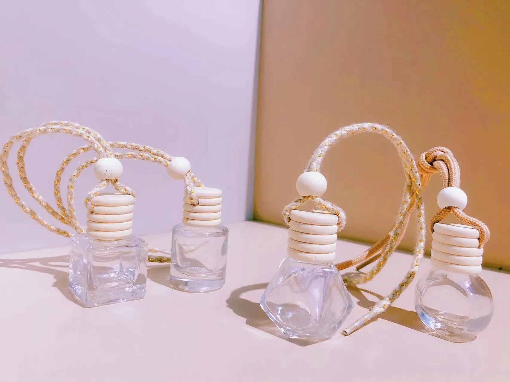 Glass car perfume pendant air freshener in cylinder, diamond, flat drum, and square shapes.