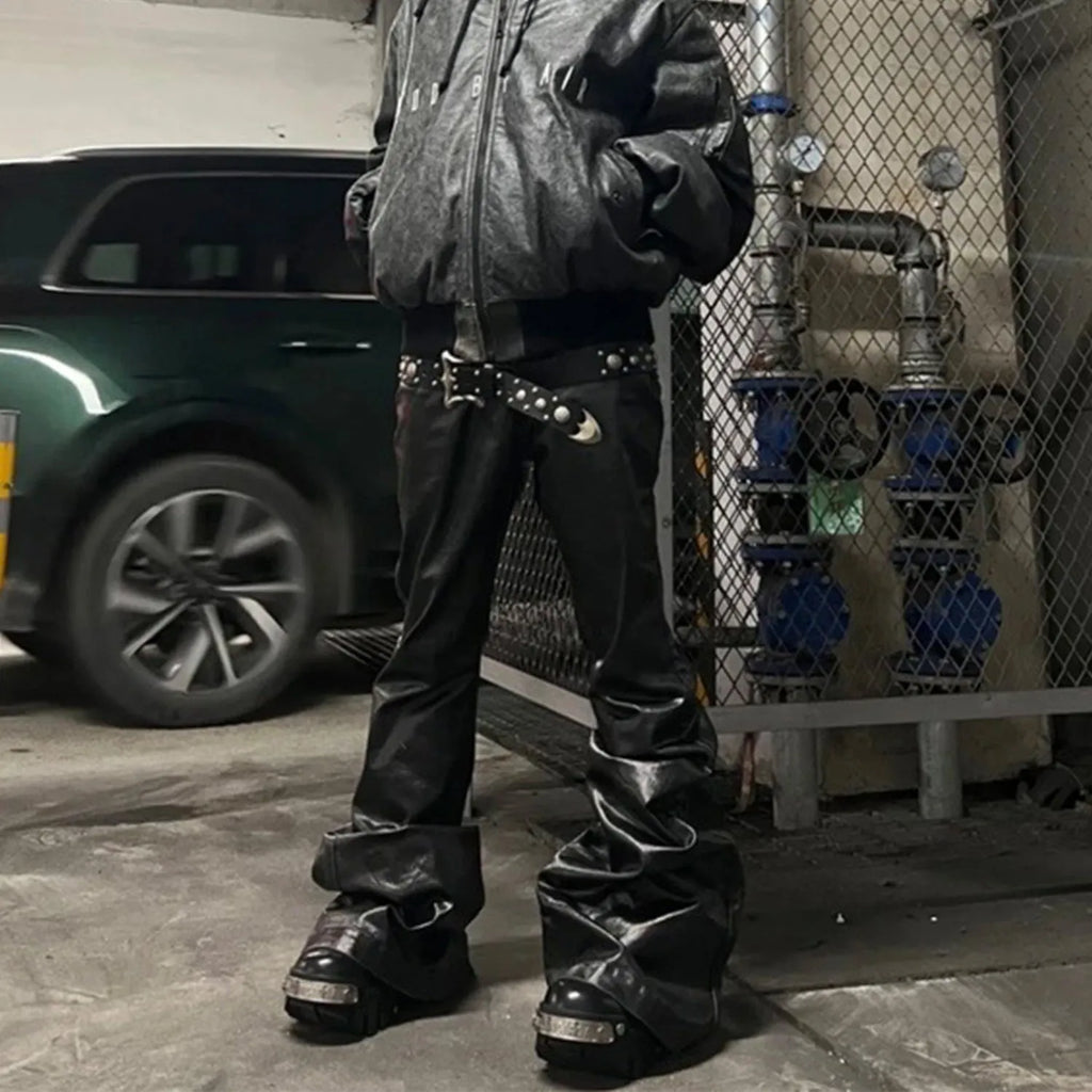 Black coated patent leather skinny jeans with a straight leg and mid-waist fit on a model.