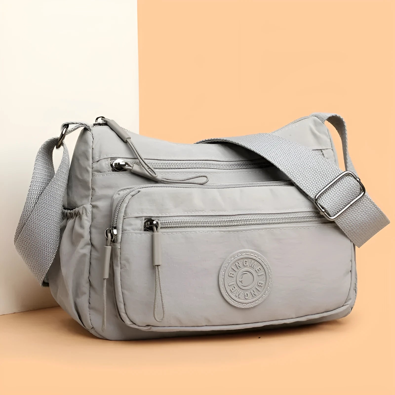 Water-repellent nylon crossbody bag with three-dimensional pockets in grey, black or red options