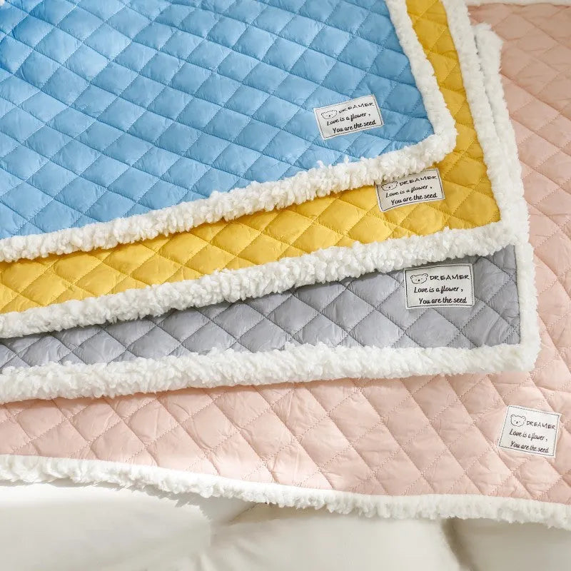 Quilted blue terry cloth pet blanket for cats on a white background, showing size scale.