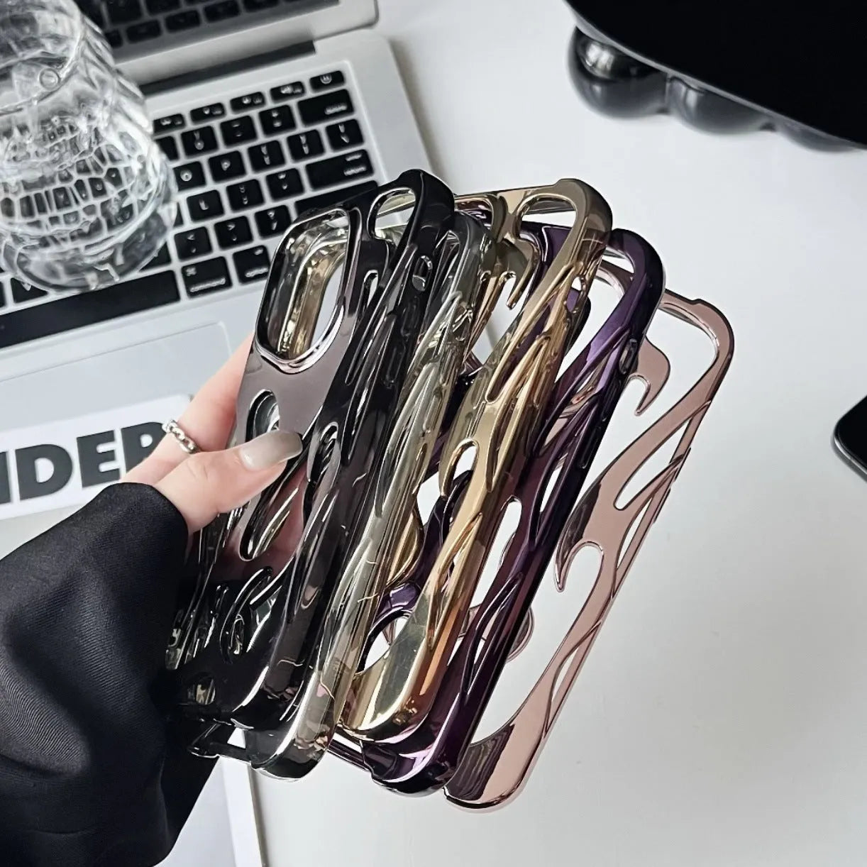 Electroplated hollow flame pattern soft TPU phone case for Apple iPhone on a table.