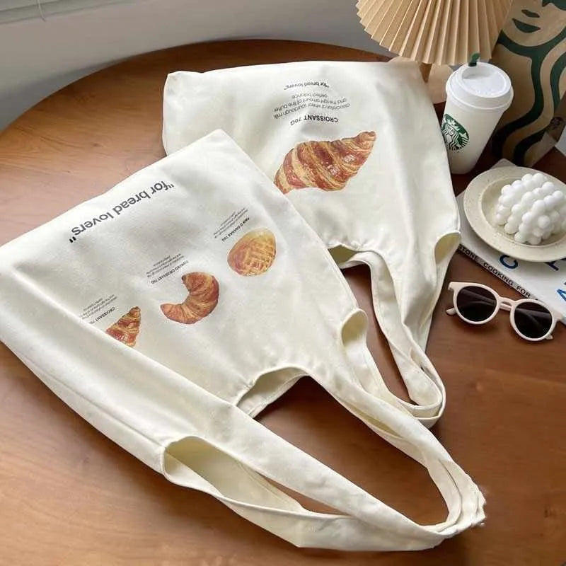 Beige canvas shoulder bag with bread design showing 44cm width and adjustable shoulder strap