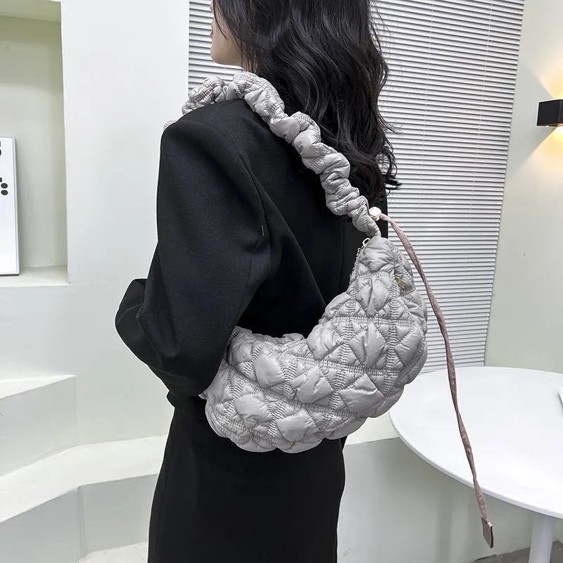Women's solid colour nylon messenger bag with long shoulder strap shown in beige.