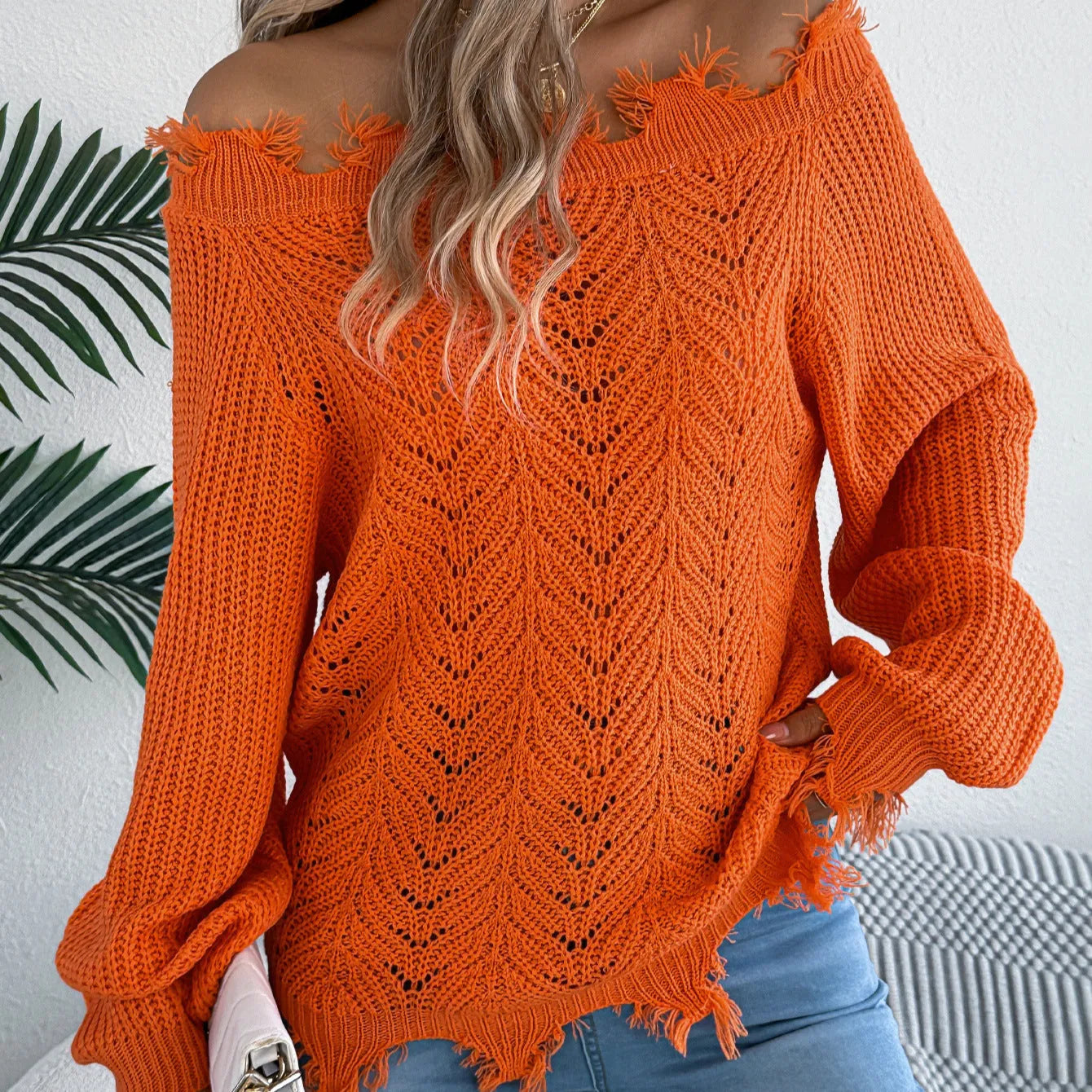 White hollow-out cut off-the-shoulder acrylic wool pullover sweater on a hanger.