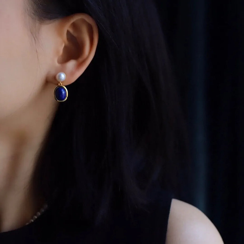 A pair of simple 925 silver drop earrings with a blue lapis lazuli pearl and auspicious patterns.