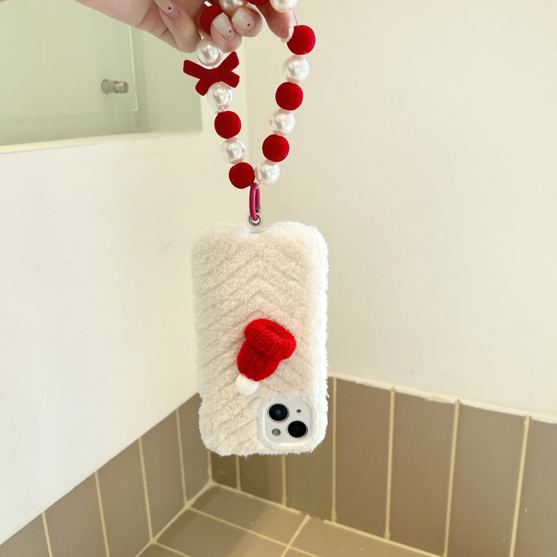 Red silicone iPhone back cover with attached plush Christmas hat bracelet