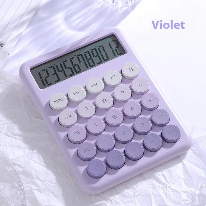 Gradient colour desktop calculator with large keys on a desk, shown in violet, pink, blue, and green colour options.
