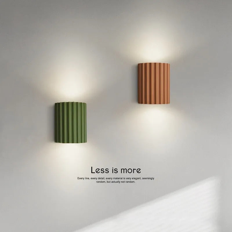 Nordic style wall light with a white macaron shell-shaped shade mounted on a hallway wall.