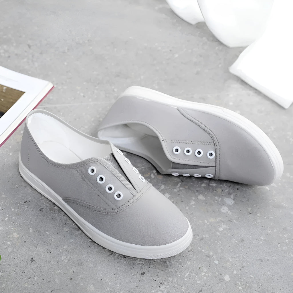 A pair of low-top canvas casual shoes on a white background, shown in one of the available colours.
